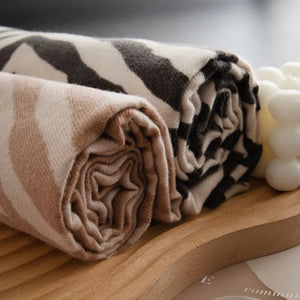 Zebra stripe wool scarf in khaki and black, rolled for display.