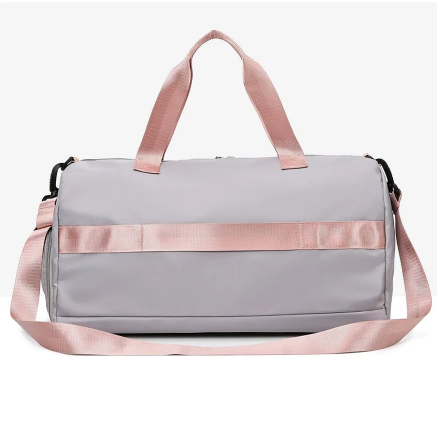 Gray duffel bag with pink straps and buckle detail, perfect for gym or travel.