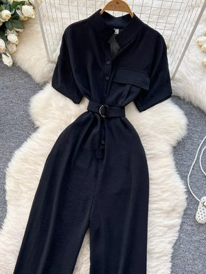 Black belted wide leg romper with short sleeves and button-down front.