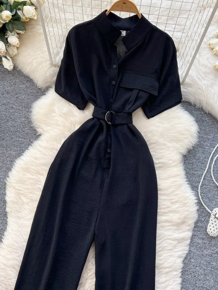 Black belted wide leg romper with short sleeves and button-down front.