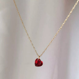 Gold chain necklace with a red heart-shaped zircon pendant.