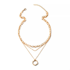 Gold layered necklace with a circular pendant and mixed chain styles