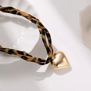tan necklace featuring pendant and leopard