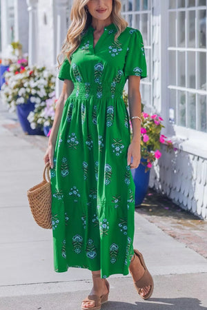 Vibrant green floral maxi dress with smocked waist, V-neck, short sleeves, and tiered skirt.