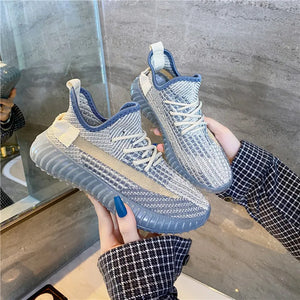 Textured knit platform sneakers in light gray with blue accents and a tan stripe detail.