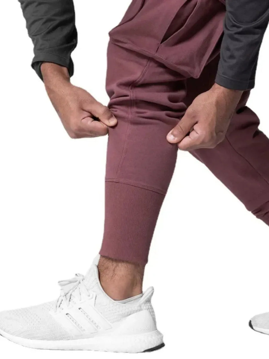Dusty pink Tech-Knit cargo joggers with ribbed cuffs and a zip pocket detail.