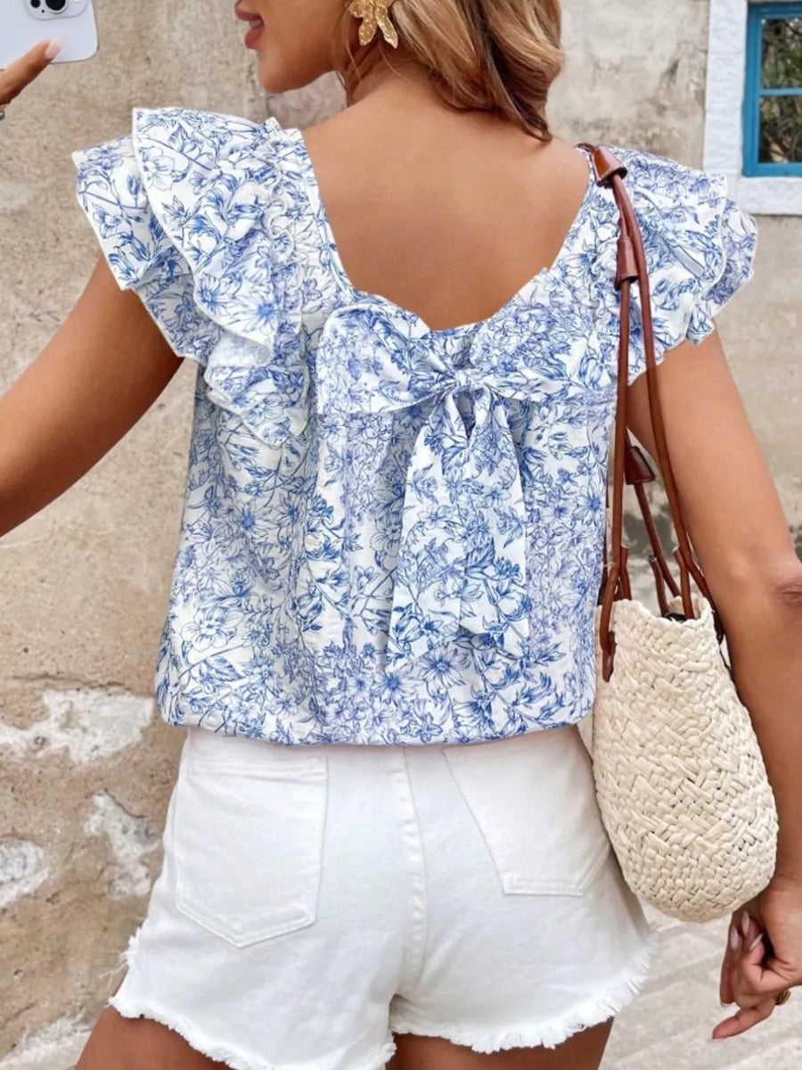Blue floral ruffle blouse with back bow detail and short sleeves.