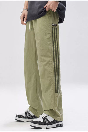 Light green wide-leg cargo pants for men with adjustable drawstring and side stripe detail.