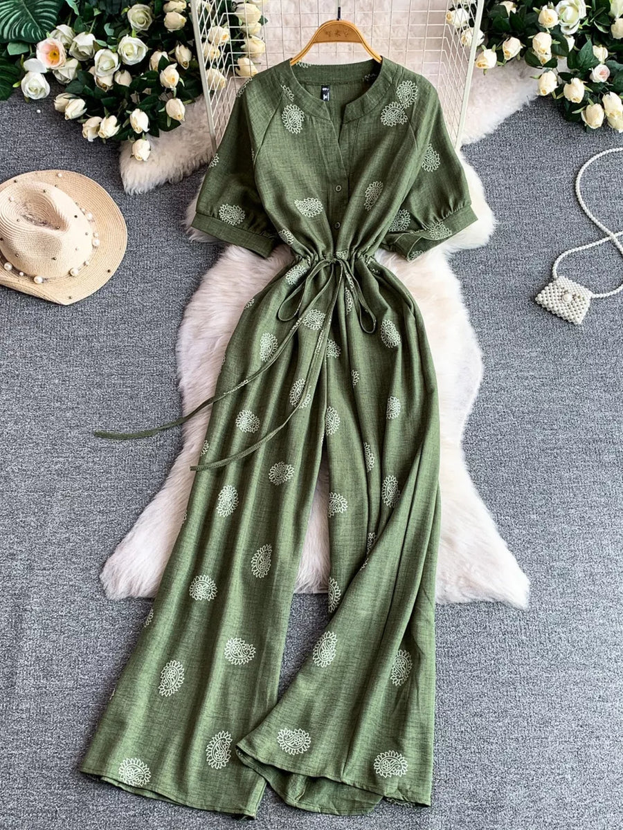 Green paisley print drawstring jumpsuit with short sleeves and wide legs.