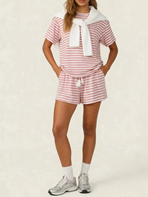 Pink striped tee and drawstring shorts set with white tassels, styled with a white sweater.