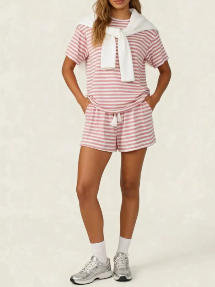 Pink striped tee and drawstring shorts set with white tassels, styled with a white sweater.
