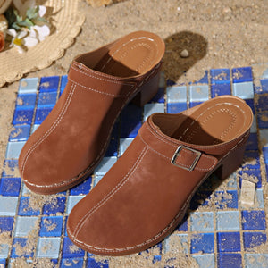 Brown round toe platform slip-ons with buckle detail and contrast stitching.