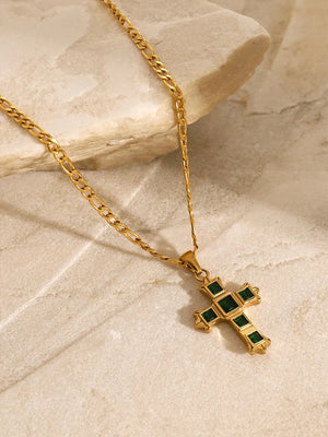 Gold cross pendant necklace with green zirconia stones on a figaro chain.