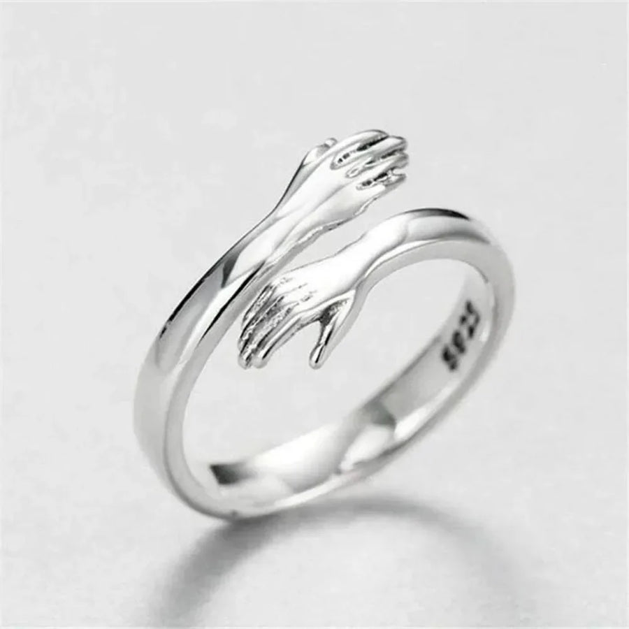 Hugging hands sterling silver ring with adjustable fit and affection design.