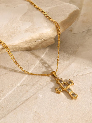 Gold cross pendant necklace with clear zirconia stones on a figaro chain.