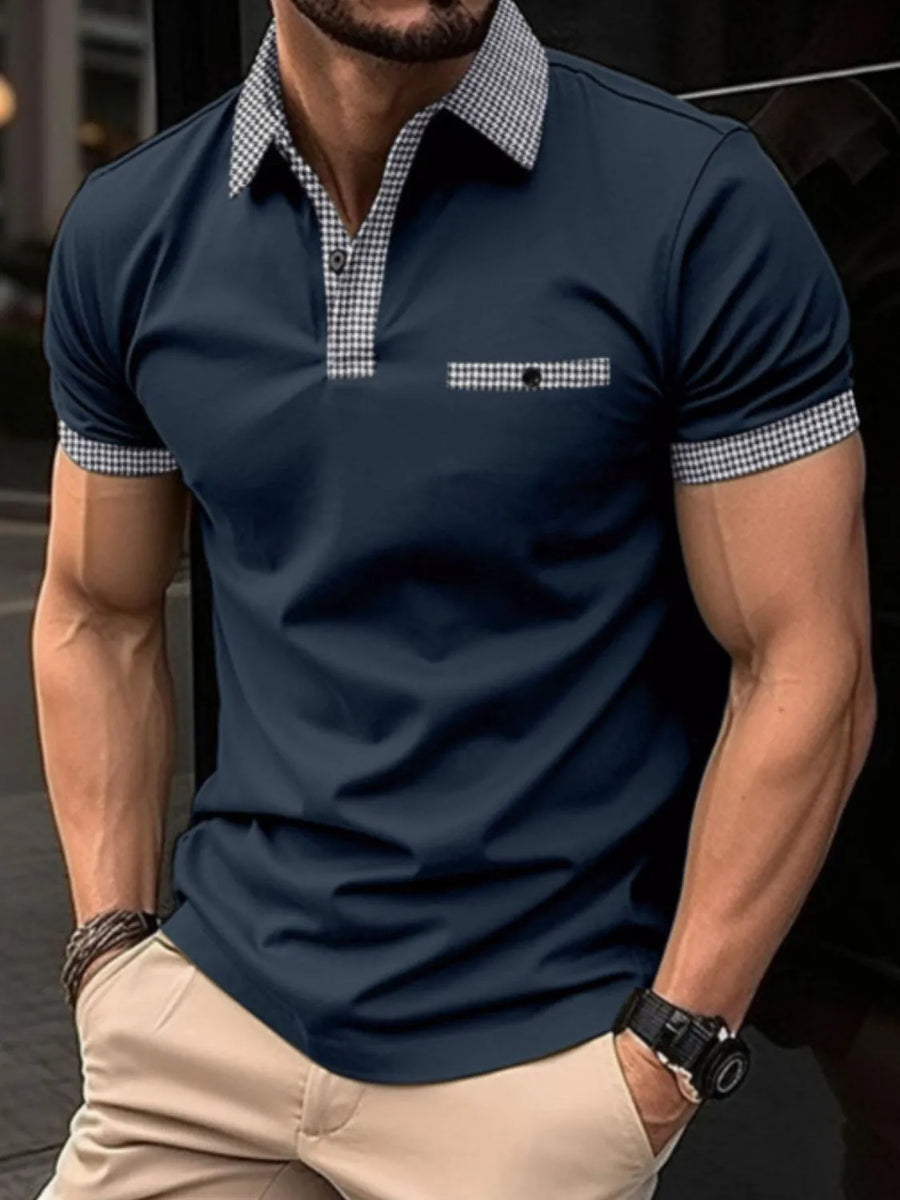 Navy polo shirt with gingham collar, pocket, and sleeve trim.