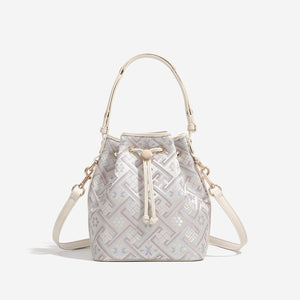 crossbody bag in cream featuring drawstring closure and bucket fit
