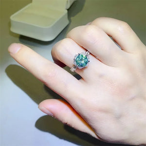 Sterling silver ring with a bright green moissanite solitaire and halo design.