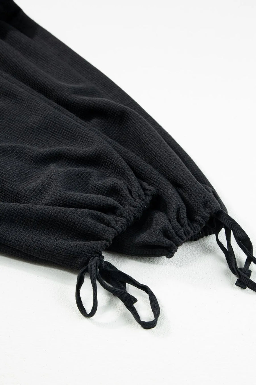 Black waffle knit jumpsuit with drawstring ankles