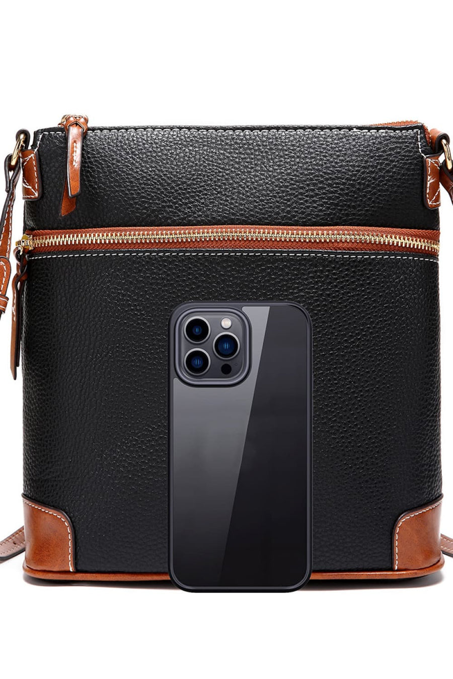 Black leather crossbody bag with brown trim and white stitching, featuring a top zipper and a phone for scale.