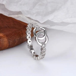 Silver interlocked pavé eternity ring with cubic zirconia accents.