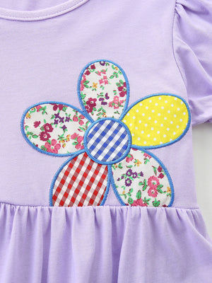 Lavender cotton toddler dress with ruffled hem and a colorful patchwork flower appliqué.
