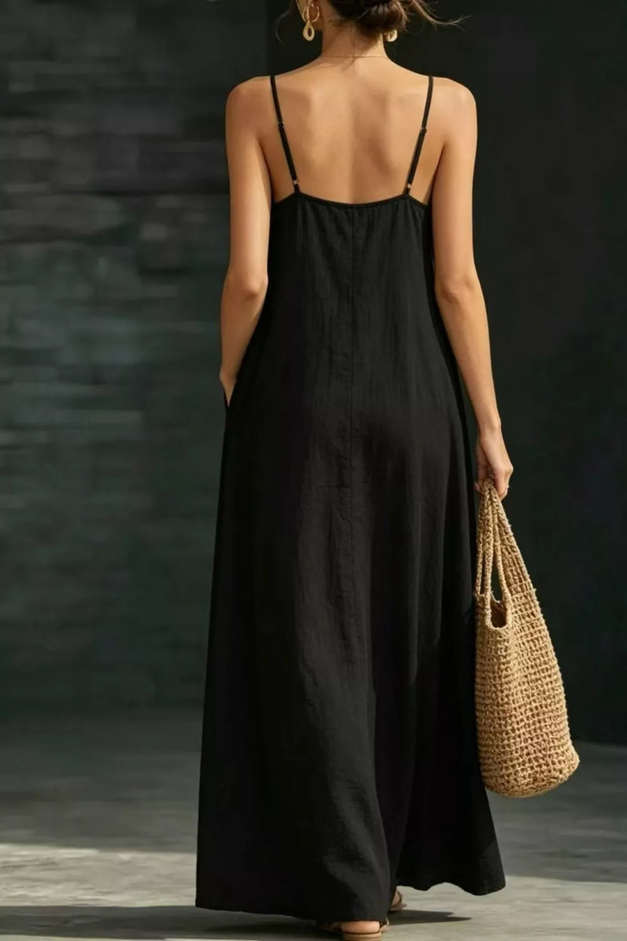 Black A-line maxi dress with spaghetti straps and pockets, shown from the back.