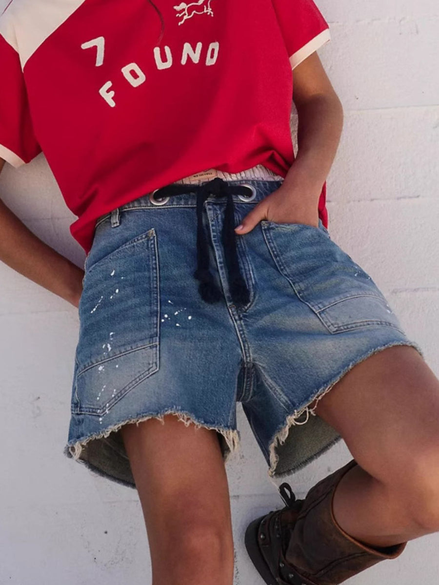 denim shorts in blue featuring raw hem and relaxed fit