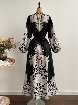 Black maxi dress with paisley print, V-neck, and balloon sleeves.