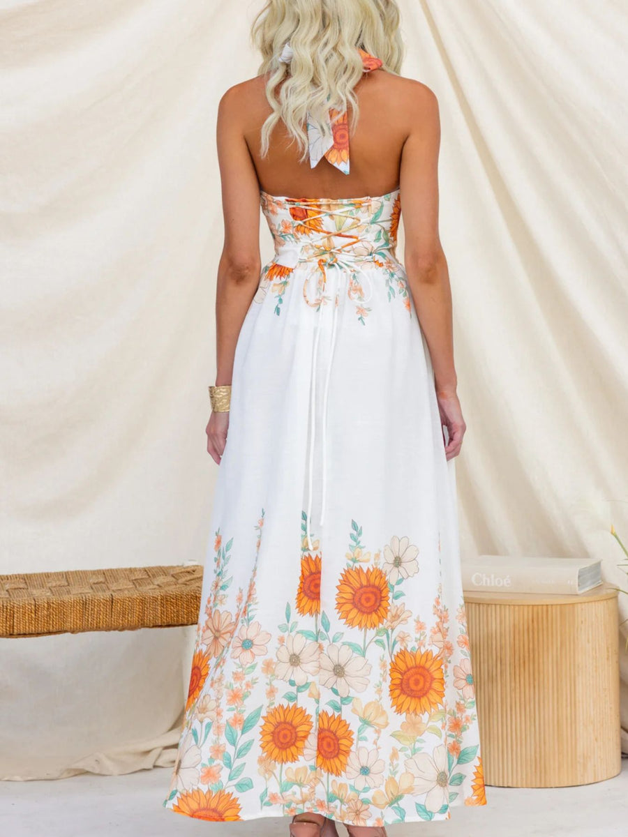 White floral halter neck maxi dress with lace-up back and border print.