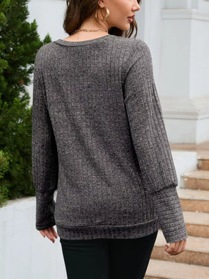 Gray textured knit long-sleeve sweater with ribbed details and a V-neck.