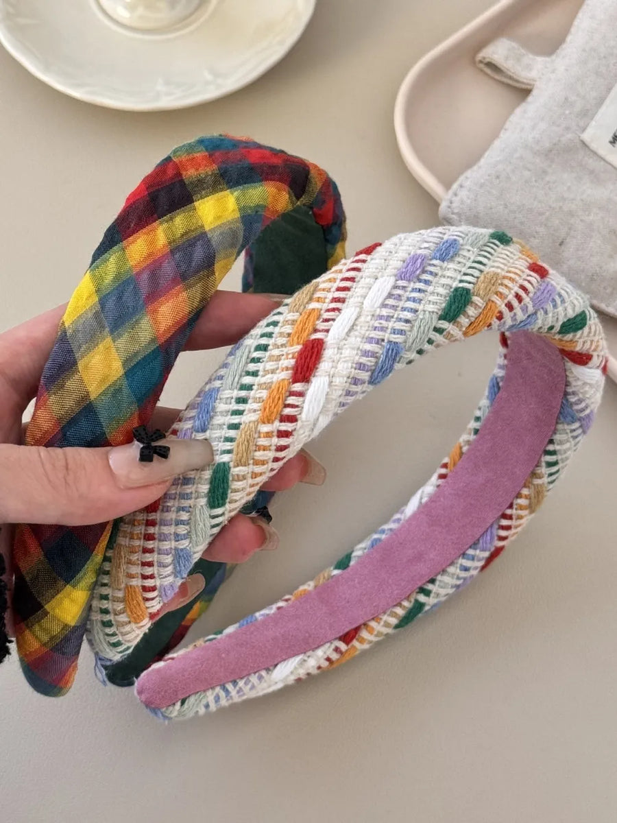 Woven plaid padded headband in plaid and multi colors with textured weave detail.