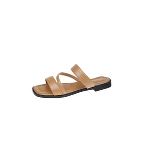 Minimalist leather crossover slides in khaki with a square toe and flat sole.