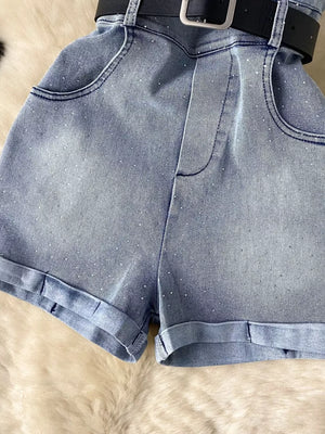 Blue denim romper with rhinestone embellishments, pockets, and a black belt.