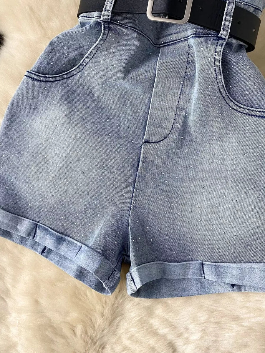 Blue denim romper with rhinestone embellishments, pockets, and a black belt.