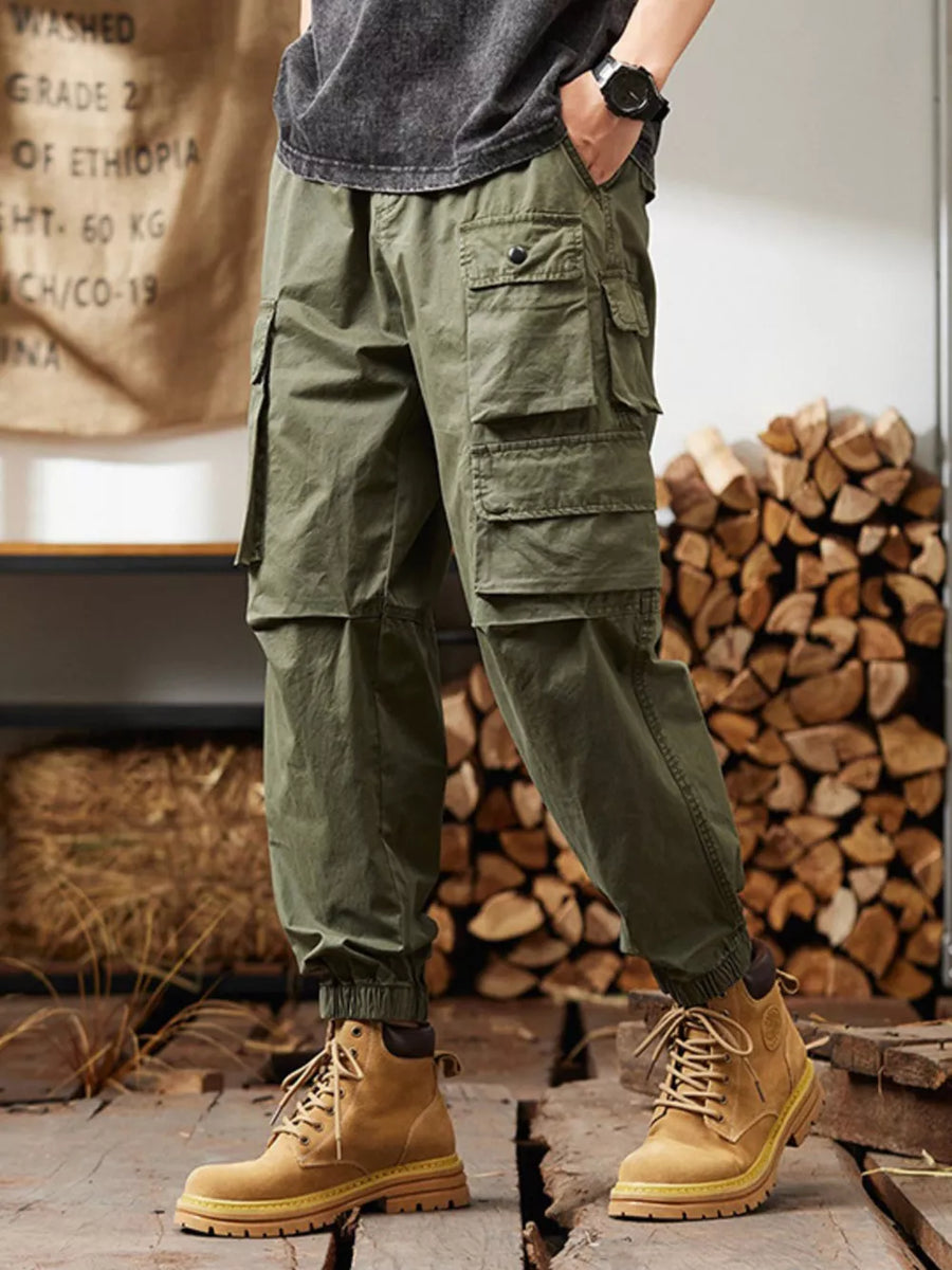 Military green cargo pants with multiple pockets and elastic cuffs.