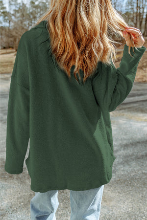 Green button-up coat with textured fabric and long sleeves.