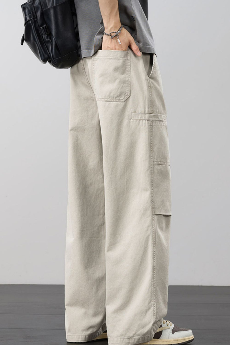 Beige cargo pants with adjustable drawstring and multiple pockets.
