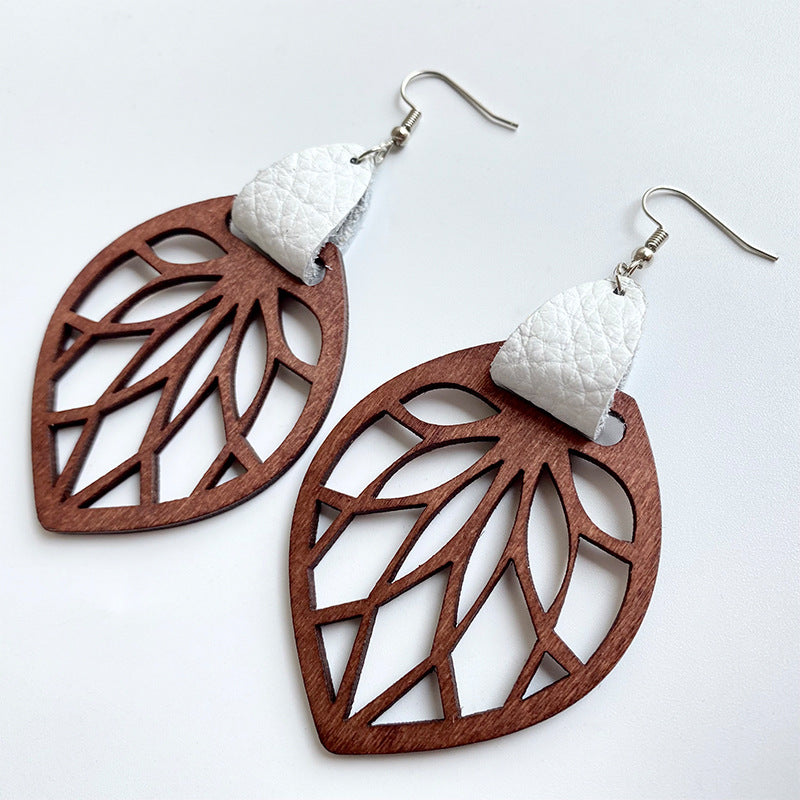 Leaf cutout wood dangle earrings with white leather detail.