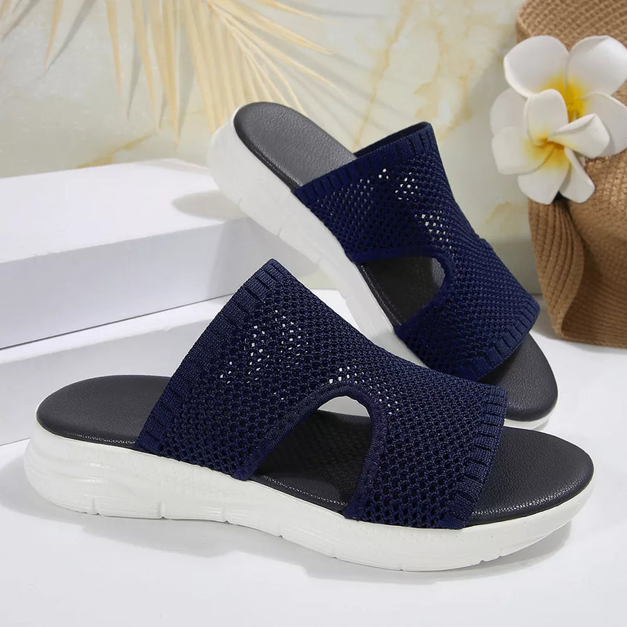Dark blue mesh slide sandals with open toe and white platform sole.