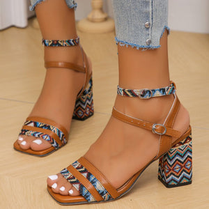 Brown open-toe block heel sandals with geometric patterned ankle straps and heel.