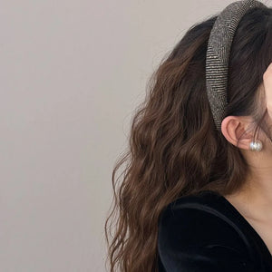 Textured tweed padded headband with geometric pattern in black and gold tones.