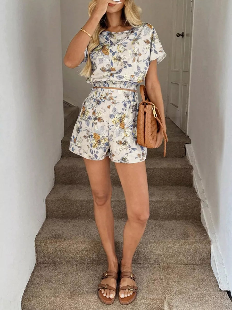 Floral two-piece set in off-white with blue and yellow flowers, featuring a crop top and shorts with pockets.