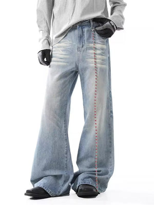 Light wash men's wide-leg jeans with distressed details and a beaded chain accent.