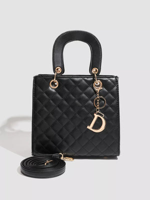 Black quilted mini top-handle tote bag with gold D charm and crossbody strap.