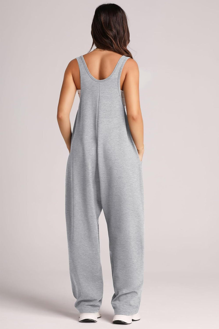 Relaxed fit pocketed tank jumpsuit in light gray with wide legs and side pockets.