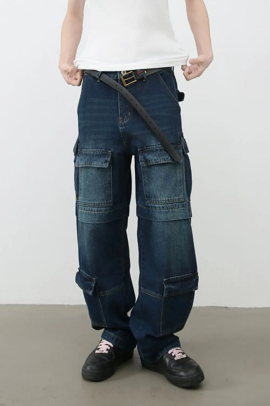 Dark wash denim cargo pants with multiple layered pockets and a relaxed fit.