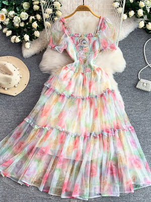 Floral tiered midi dress with smocked bodice and puff sleeves in a pastel watercolor print.
