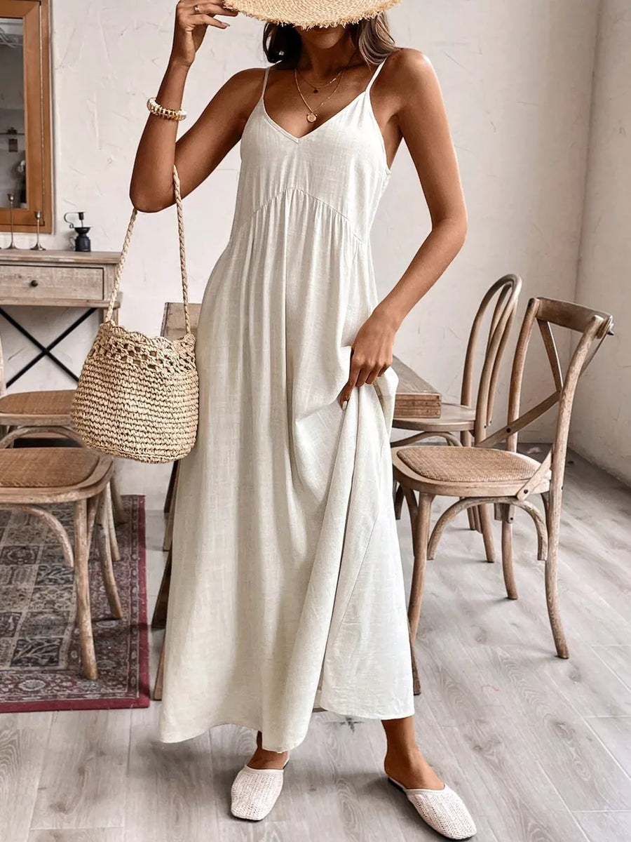 Effortless V-neck maxi dress in cream with spaghetti straps and a flowing skirt.