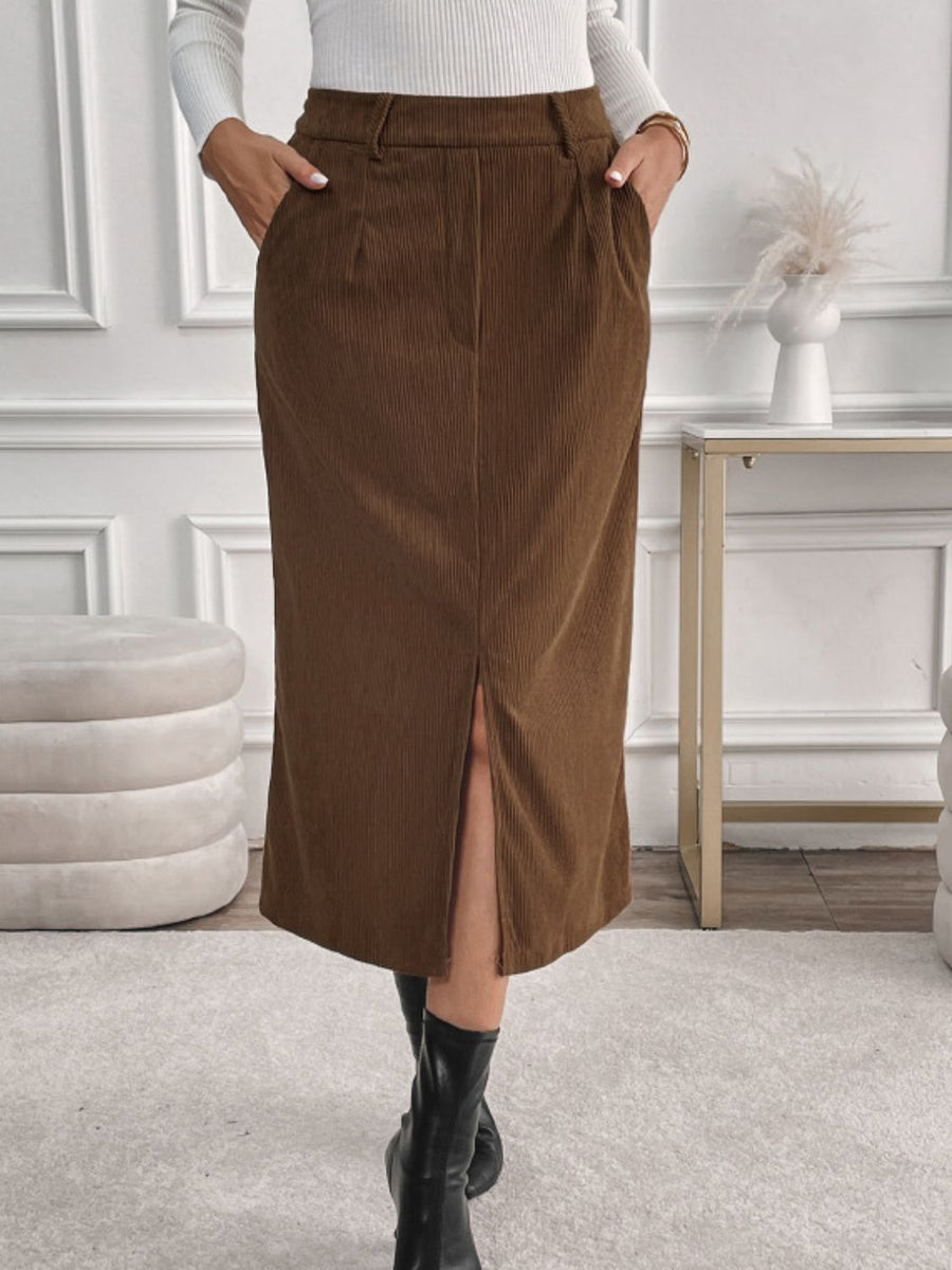 Brown corduroy midi skirt with a front slit and pockets, styled with black boots.